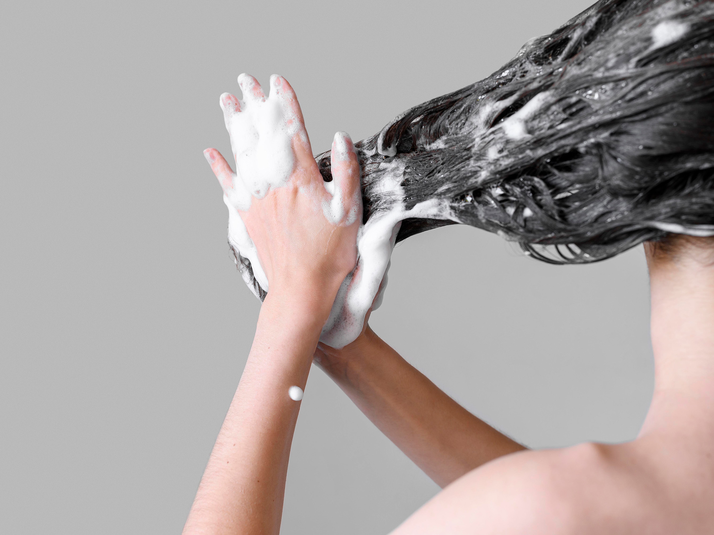 Woman using shampoo bar to wash hair
